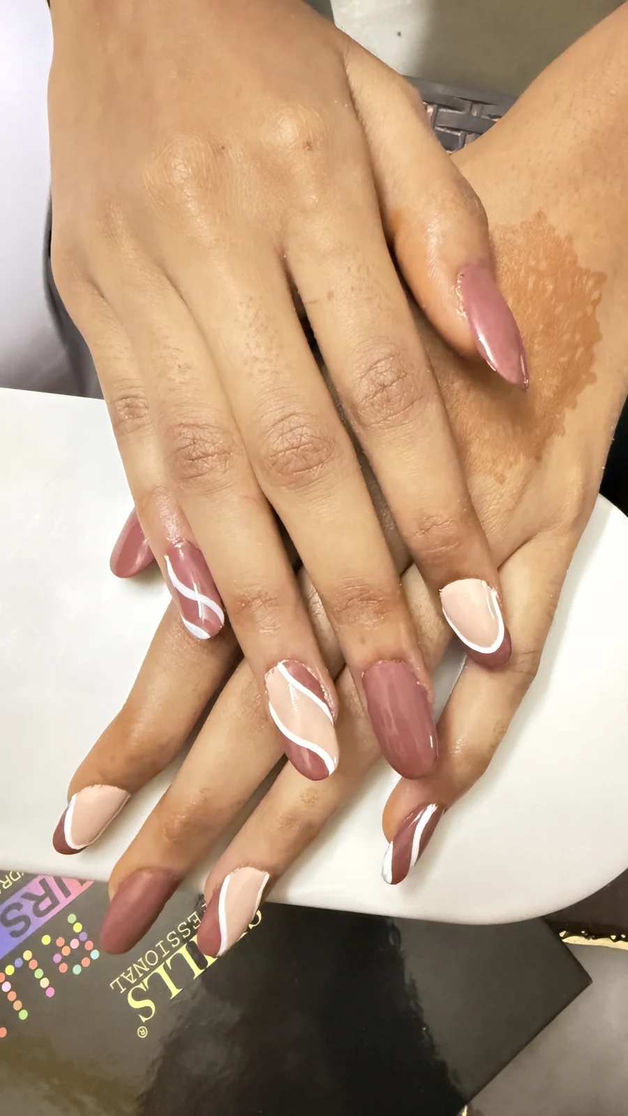 Nude and pink nails with curved white details